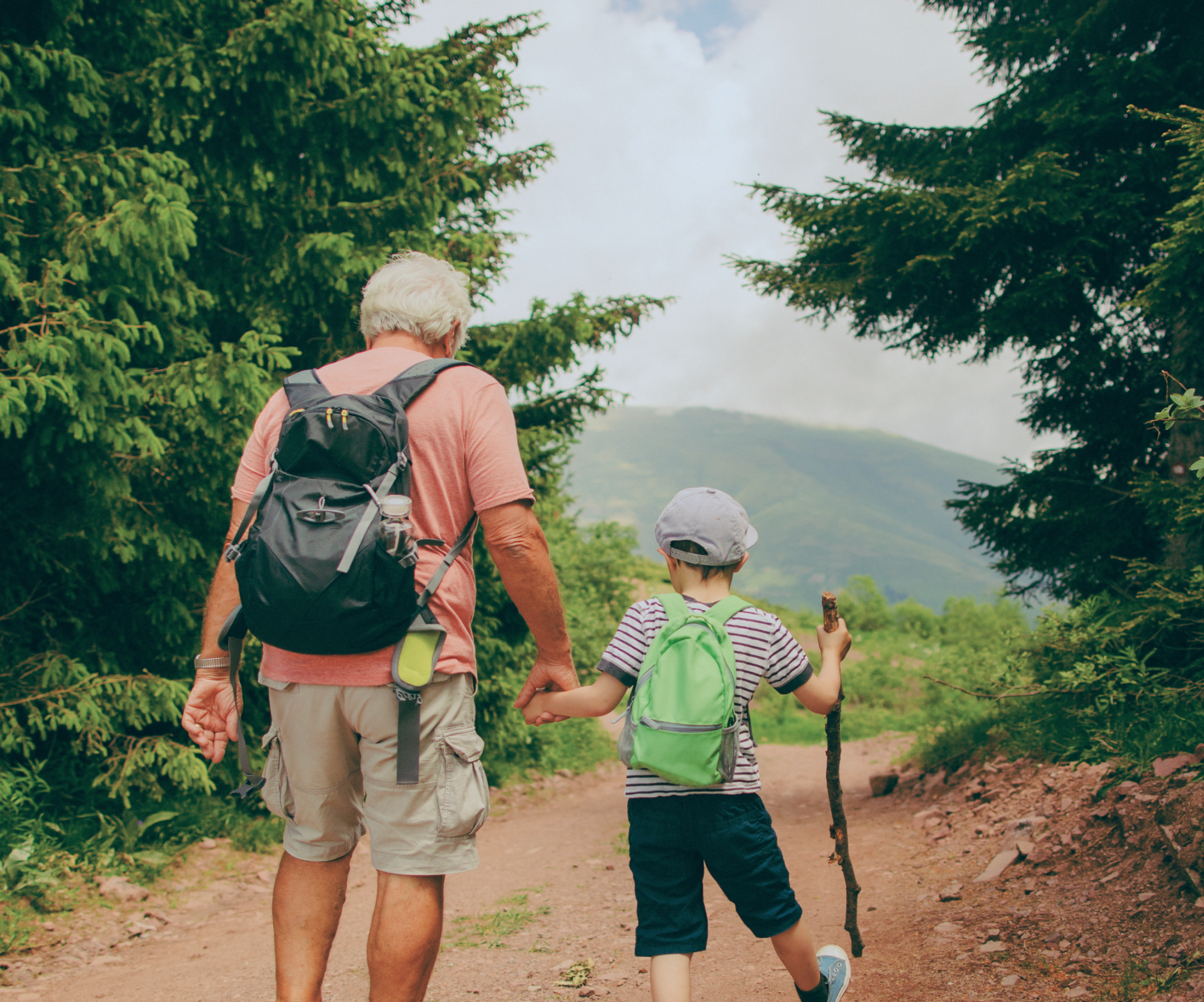 Older man hiking with child in woods.